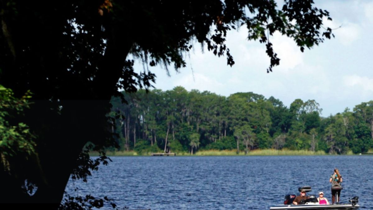 People fishing in boat on lake