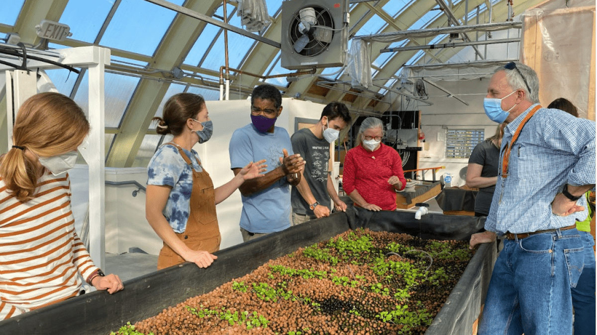 Science teachers from Brunswick High School explore the Canopy Farms facility with hosts Kate Holcomb and Theo Willis, discussing connections to their course curriculum.
