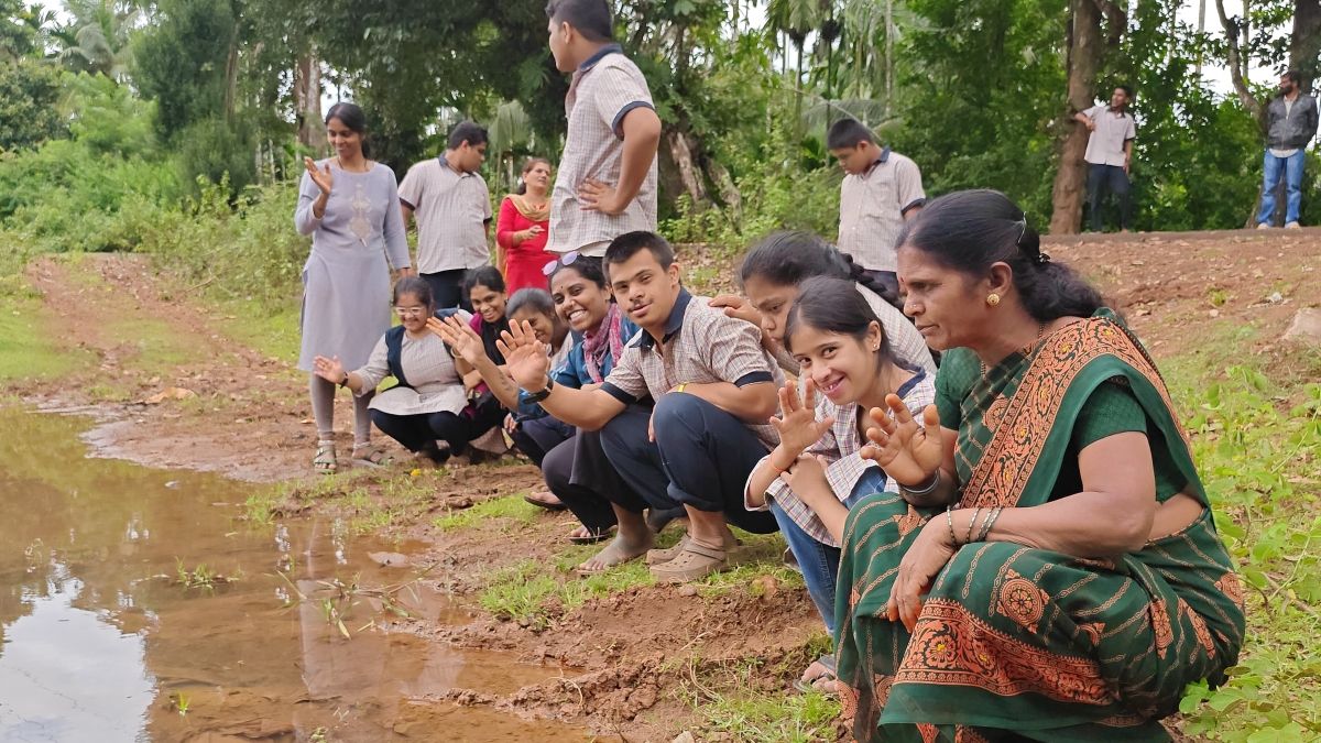 Anjali and children sitting by a stream