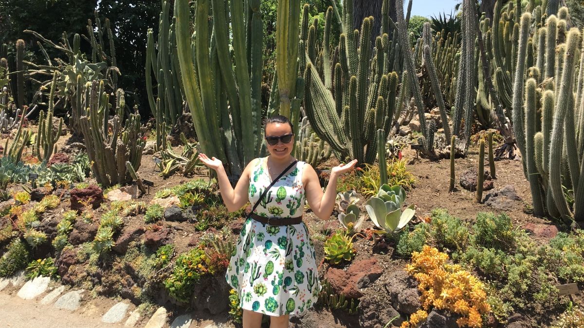 Woman standing in front of cactus garden