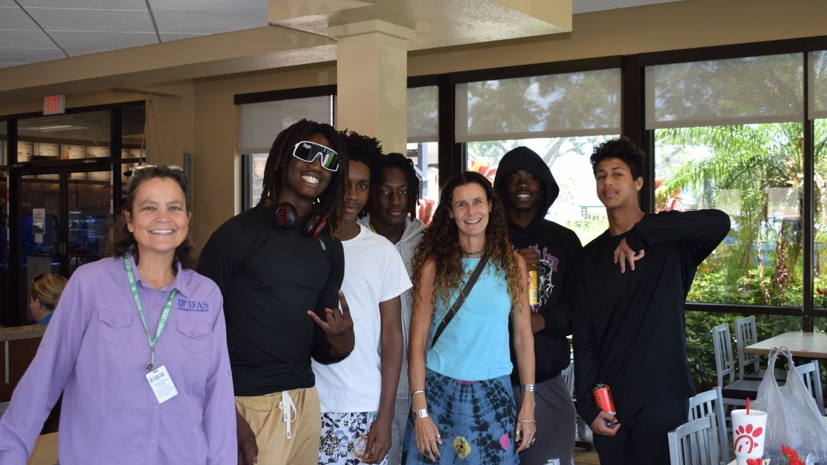 Sarah and youth posing inside