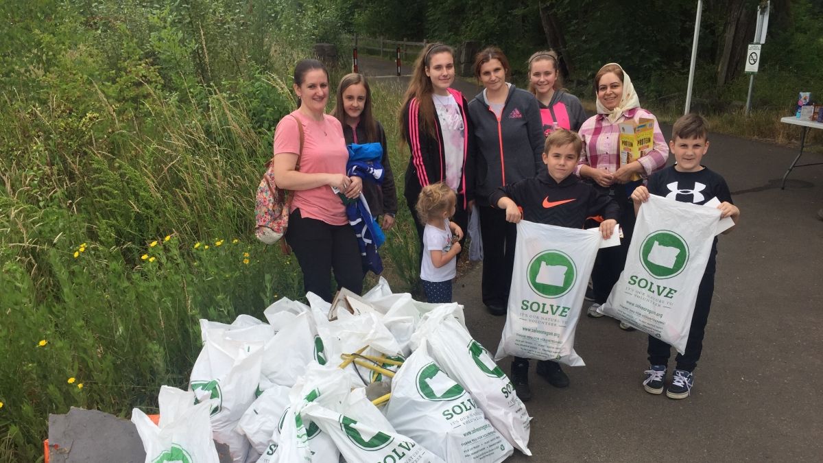 Volunteers posing with bags of trash after a cleanup event
