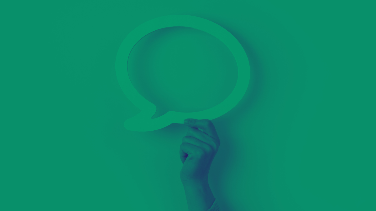 Hand holds speech bubble in green-tinted image