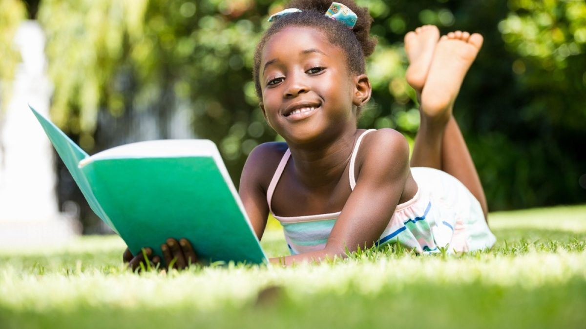 Young Black girl reading outside