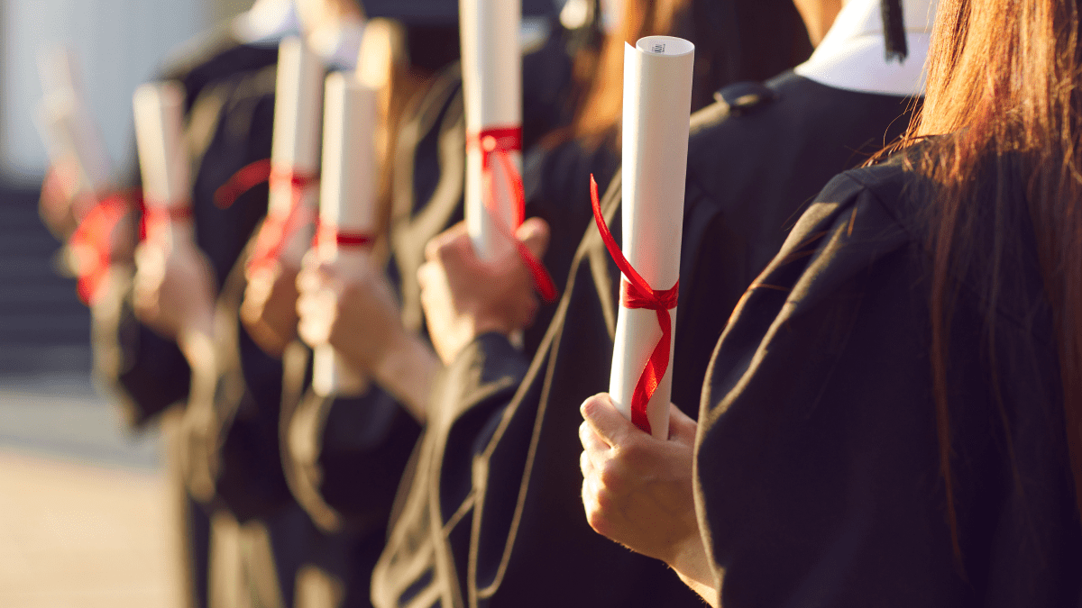A line of school graduates holding diplomas