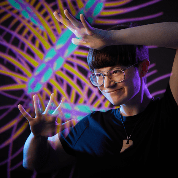 Photo of Bug Hartsock wearing glasses and and a black shirt, with a colorful illustration of a many-legged house centipede in the background