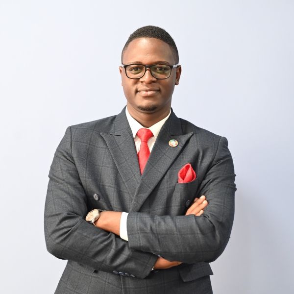 Headshot of a young man in a grey suit
