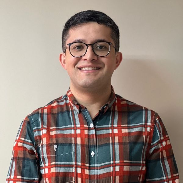 A headshot of a man with glasses, smiling