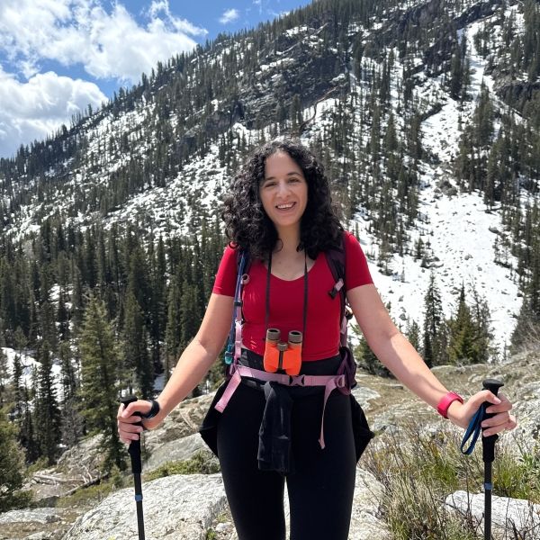 Woman with hiking poles on a trail in the mountains