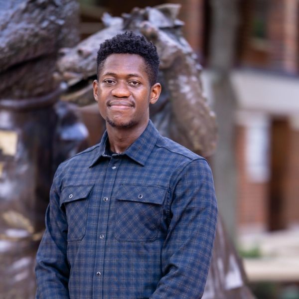 Jeftey standing outside in front of a sculpture