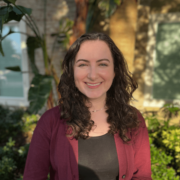 Madeline outside in front of a tree