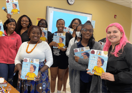 A group photo of FAMU preservice teachers holding up books