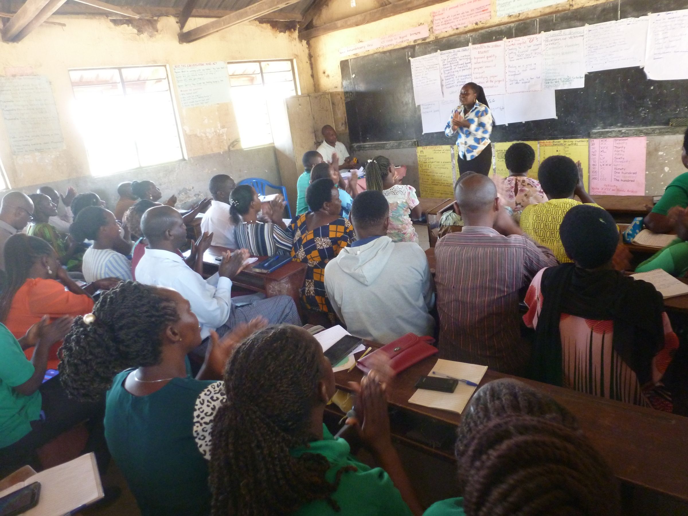 Adults gathered in a classroom in Uganda