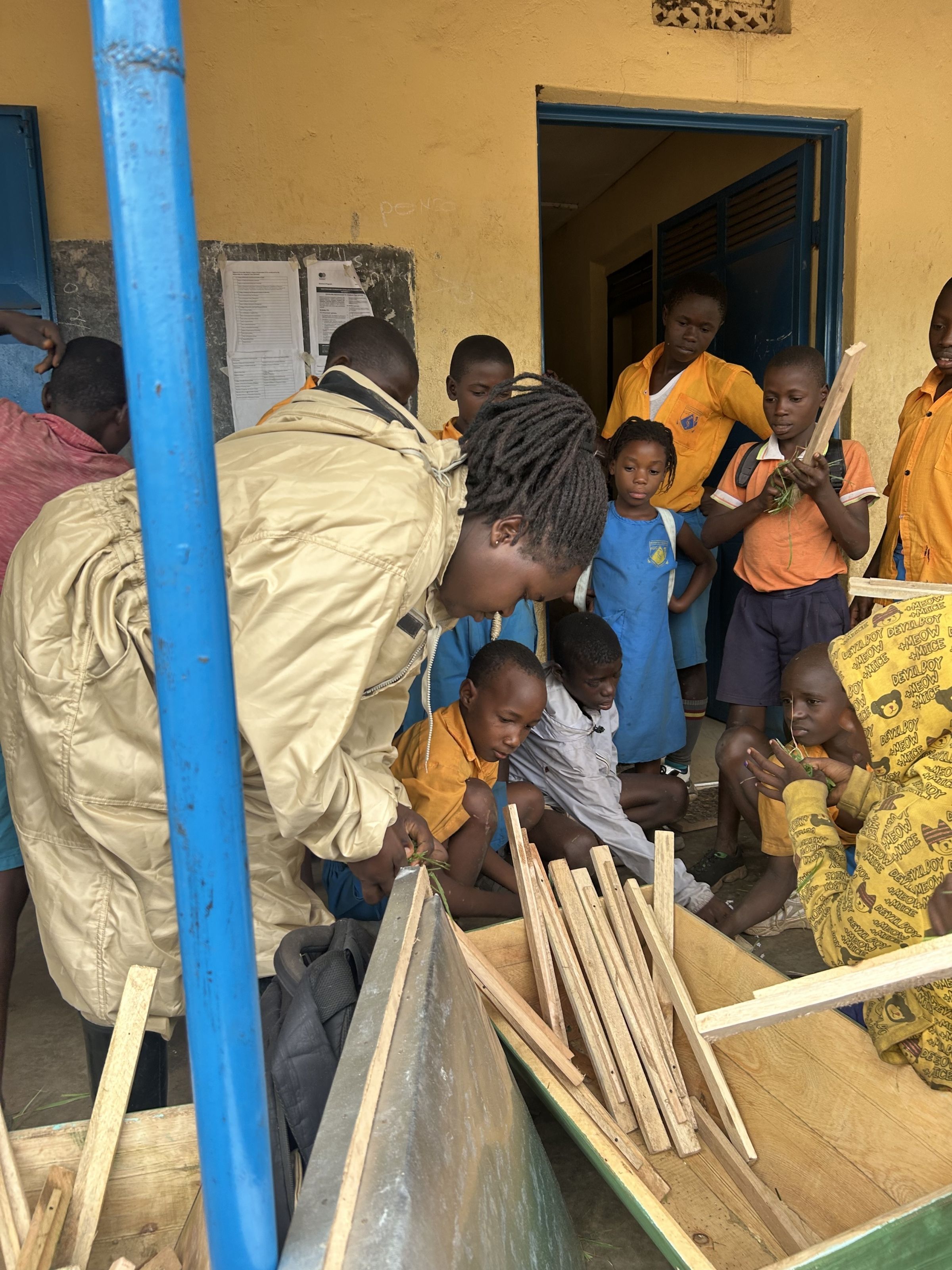 Teachers and students looking at wooden materials in a box