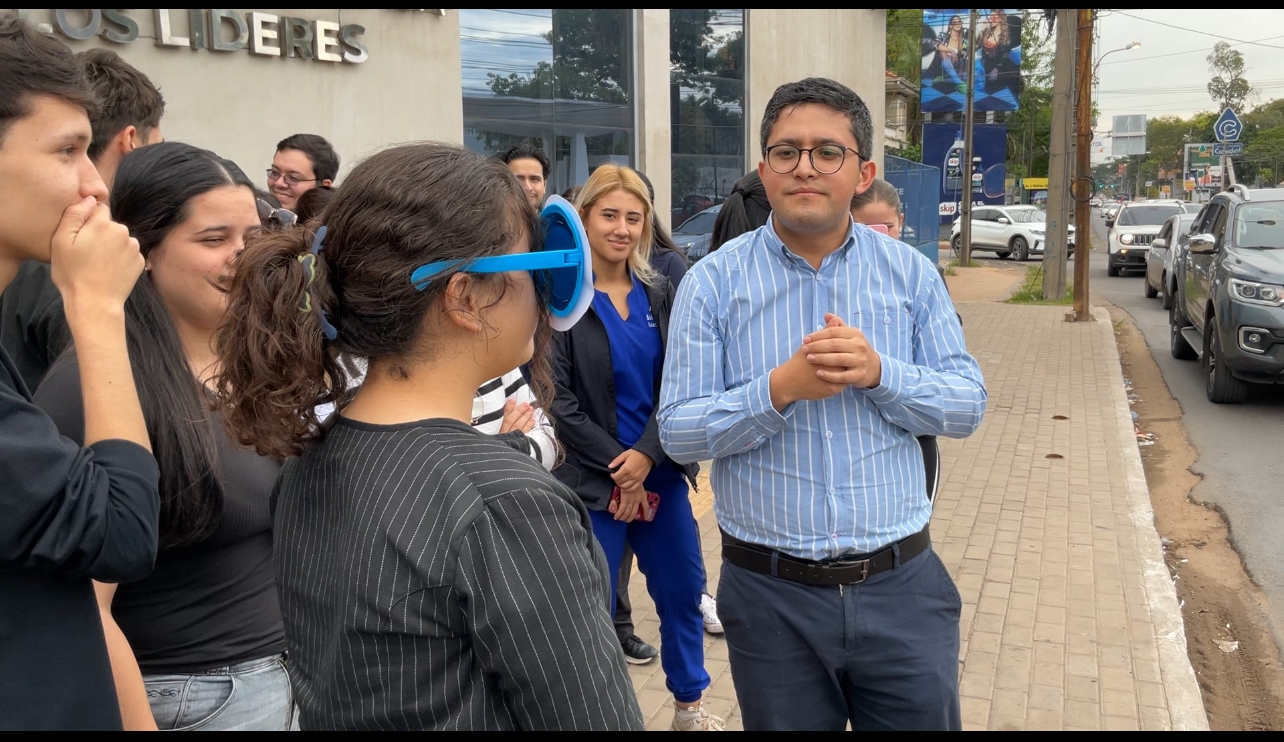 Professor and students standing outside on a sidewalk