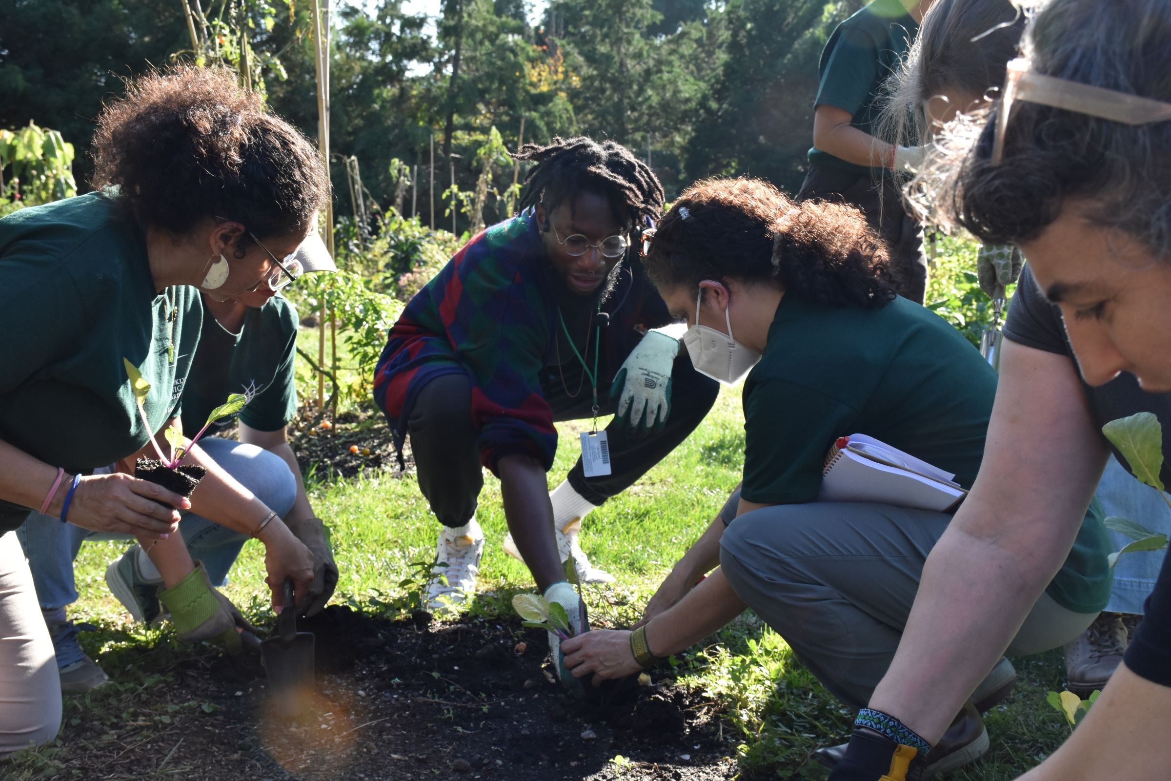 EE 30 Under 30 Awardee Jibreel leading students through a planting demonstration