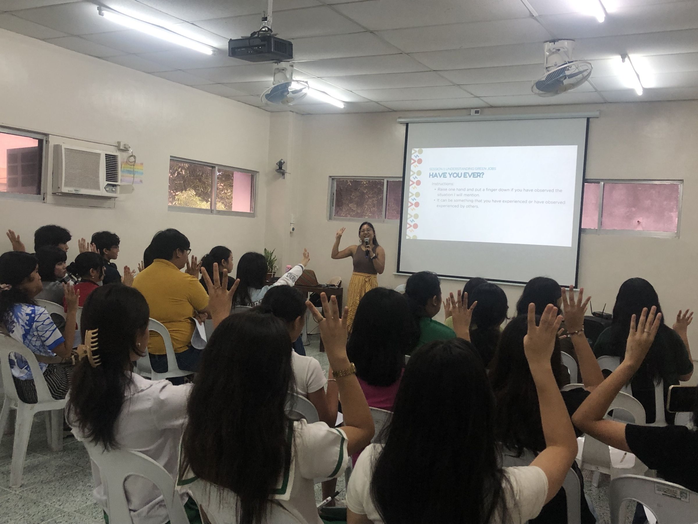 A woman at the front of a classroom of students