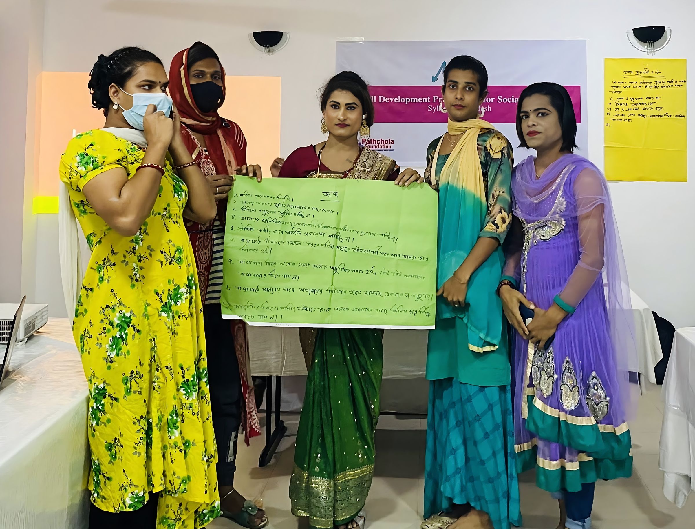 A group of 5 women holding up a poster.