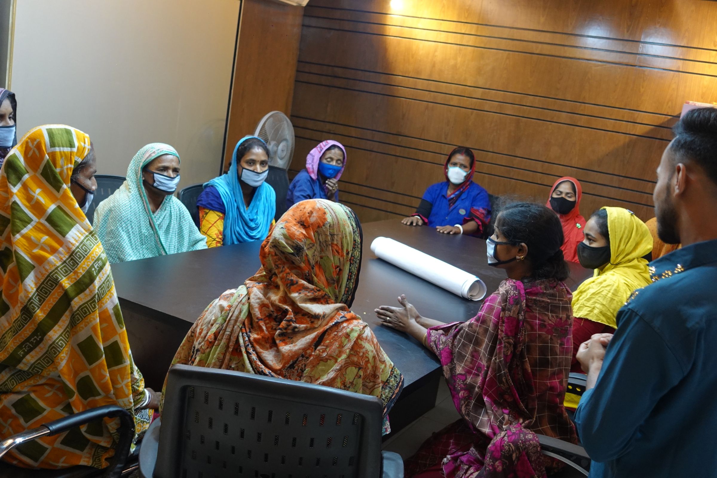 A group of women in conversation at a table.