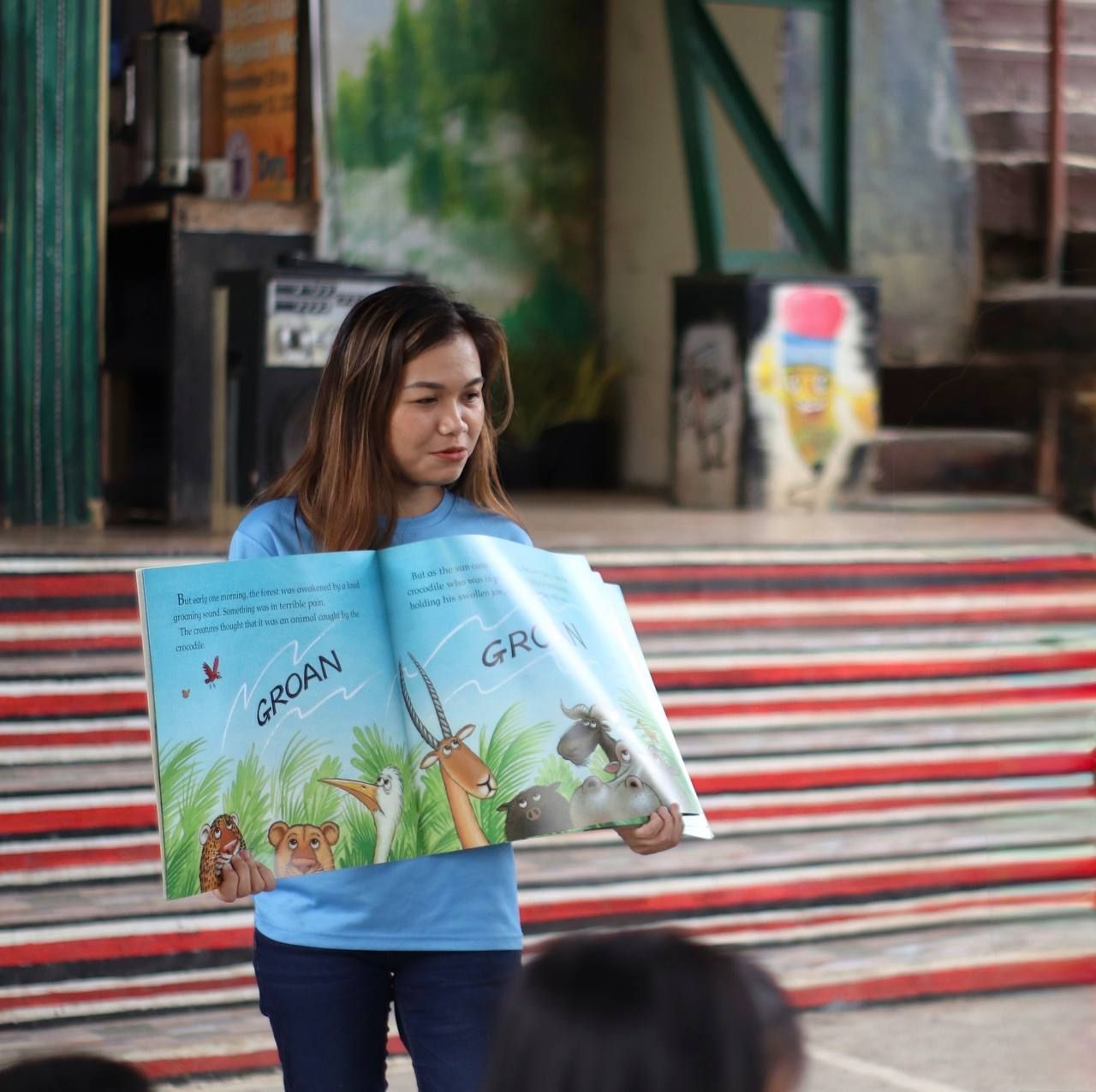 A woman holding a picture book.