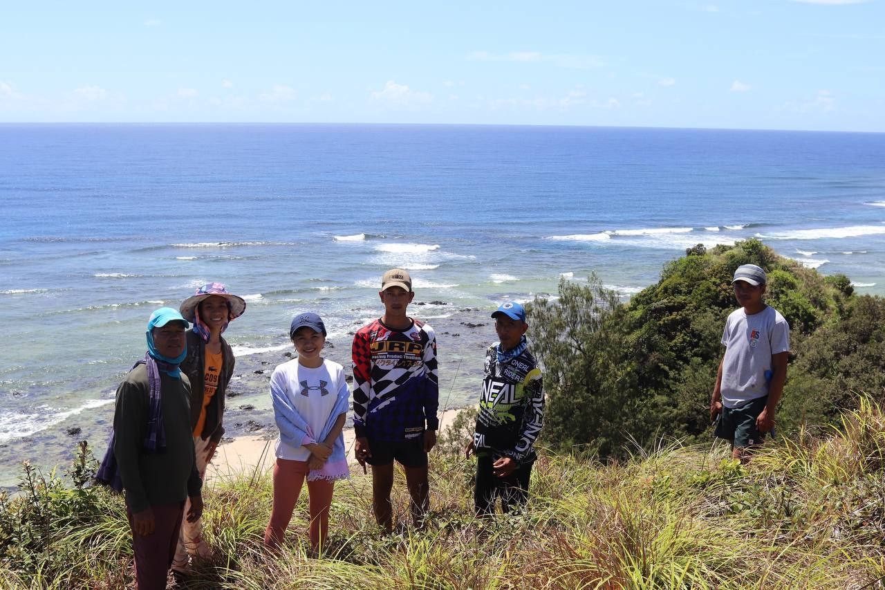 A group of people posing by the beach.