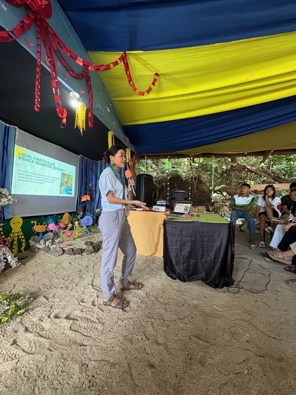 A woman speaking in front of an audience.
