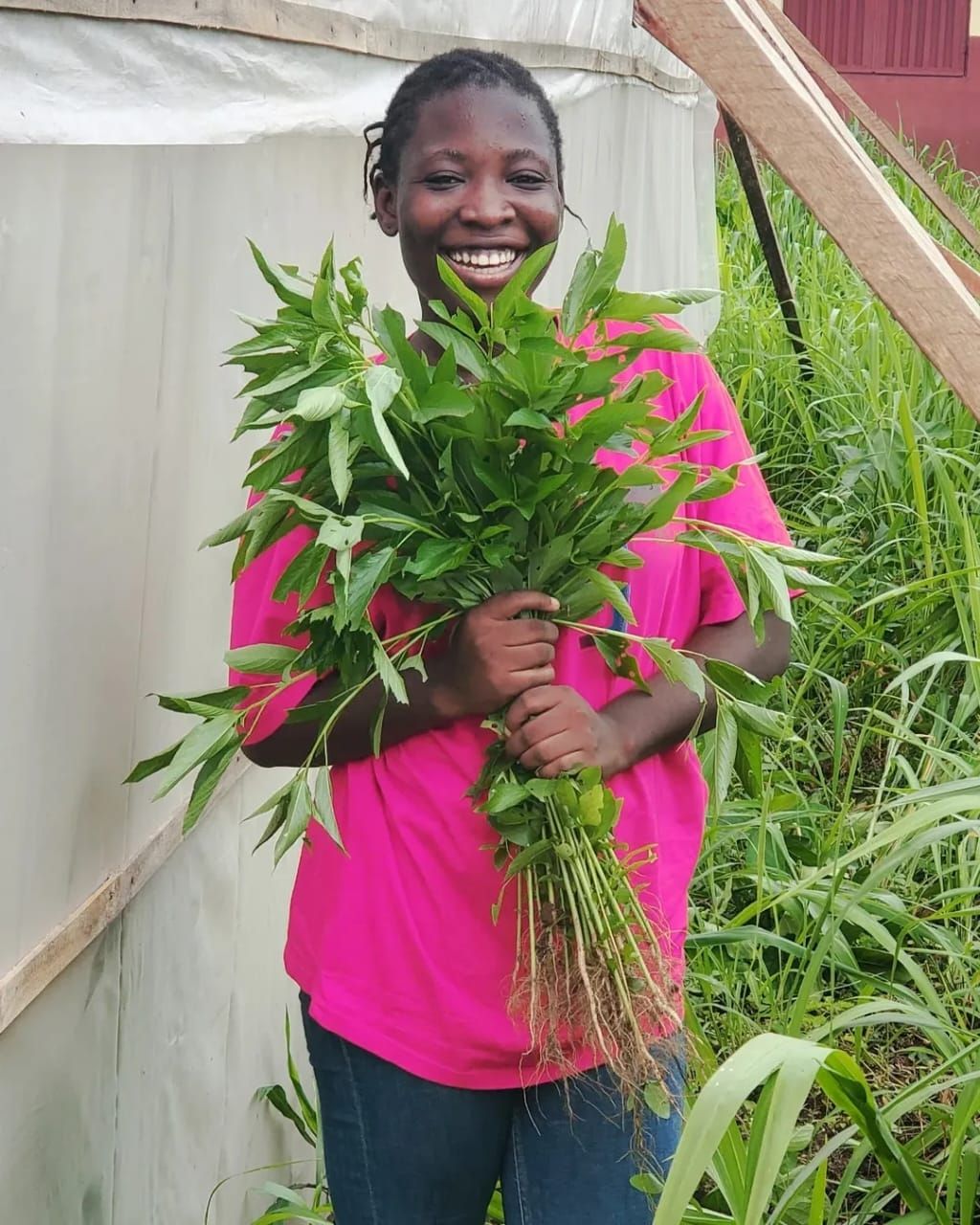 A woman holding plants from a garden.