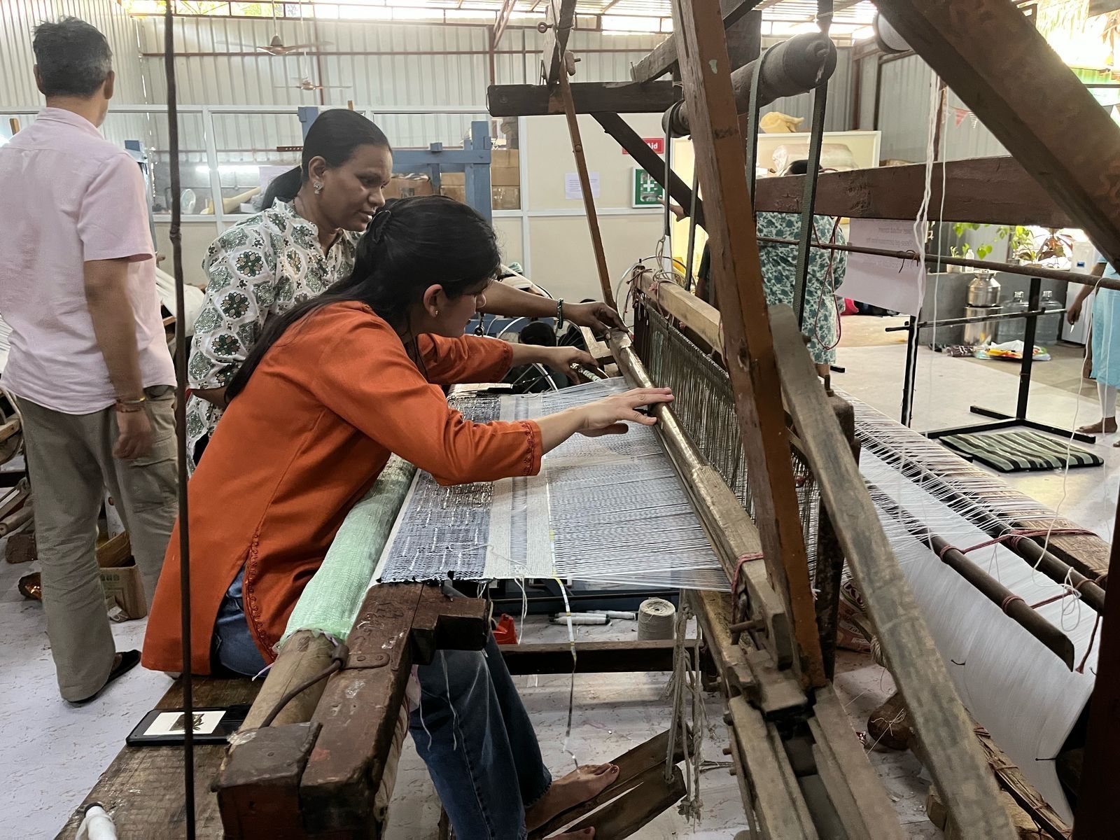 Two women weaving on a loom
