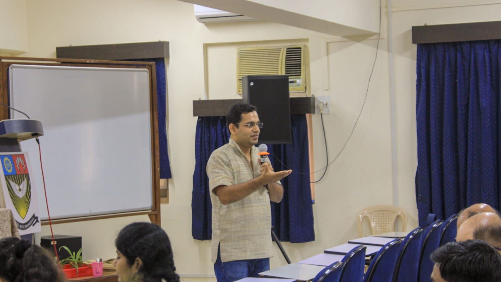 Avadhut speaking with a microphone in front of a group
