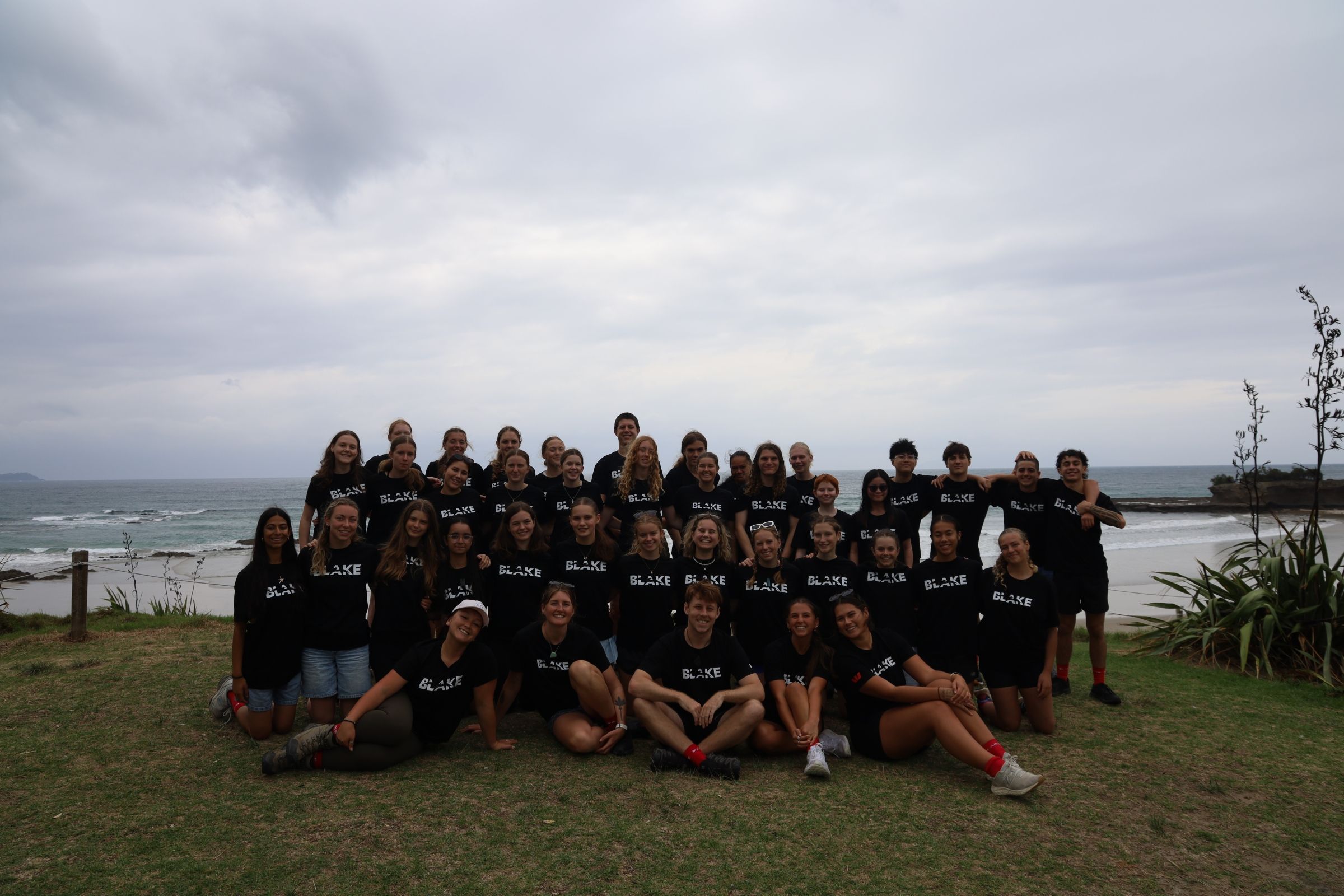 Group of students posing outside in front of the ocean