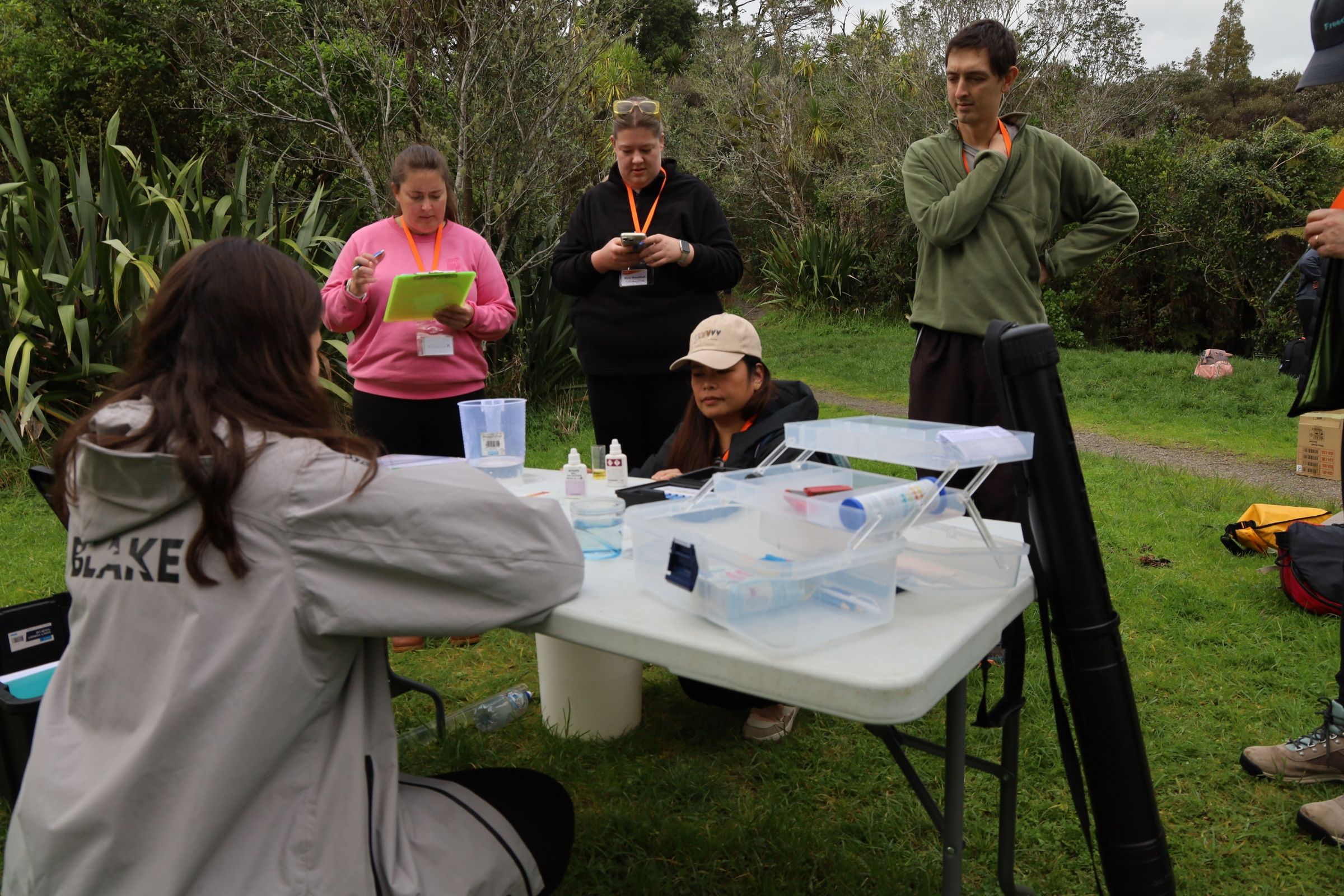 Teachers gathered around a table outside and looking at materials