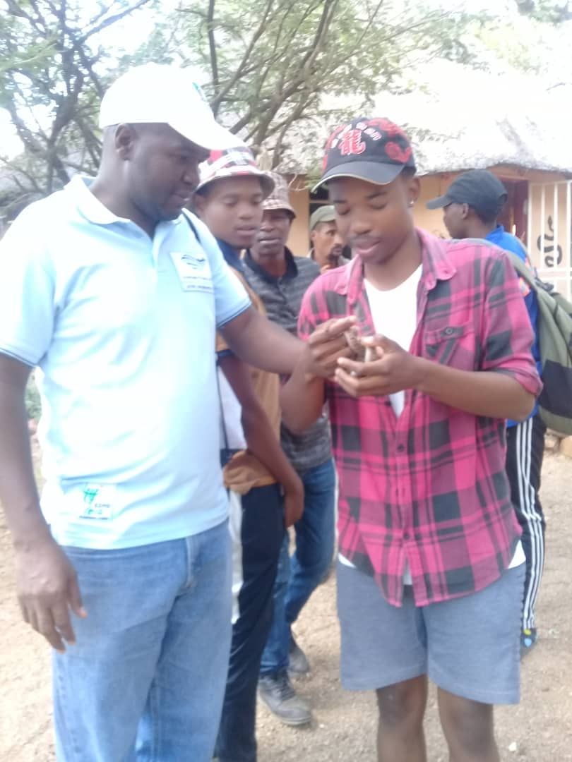 Kgosi and students handling a small snake
