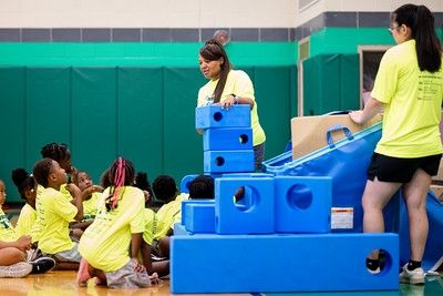 Monica with a group of young students, with bright blue blocks