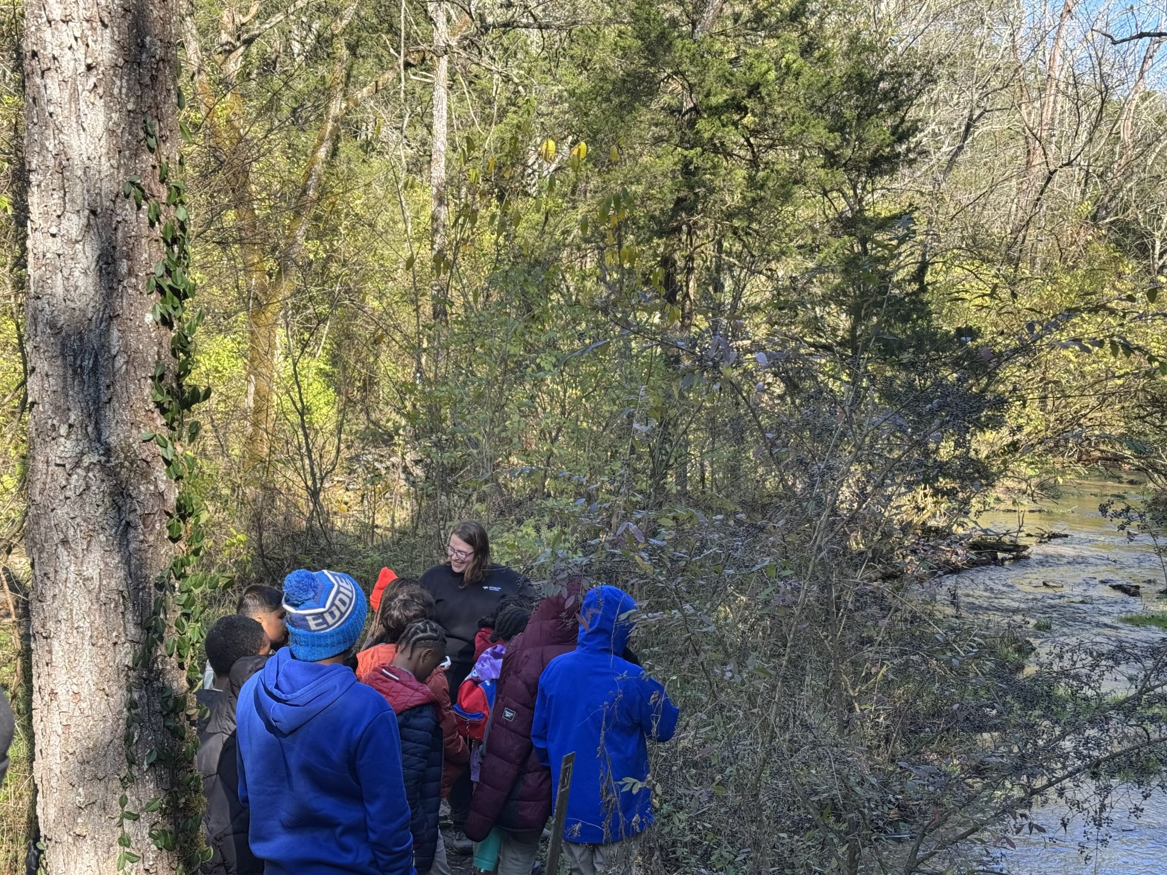 Sagan teaching students outside by a creek