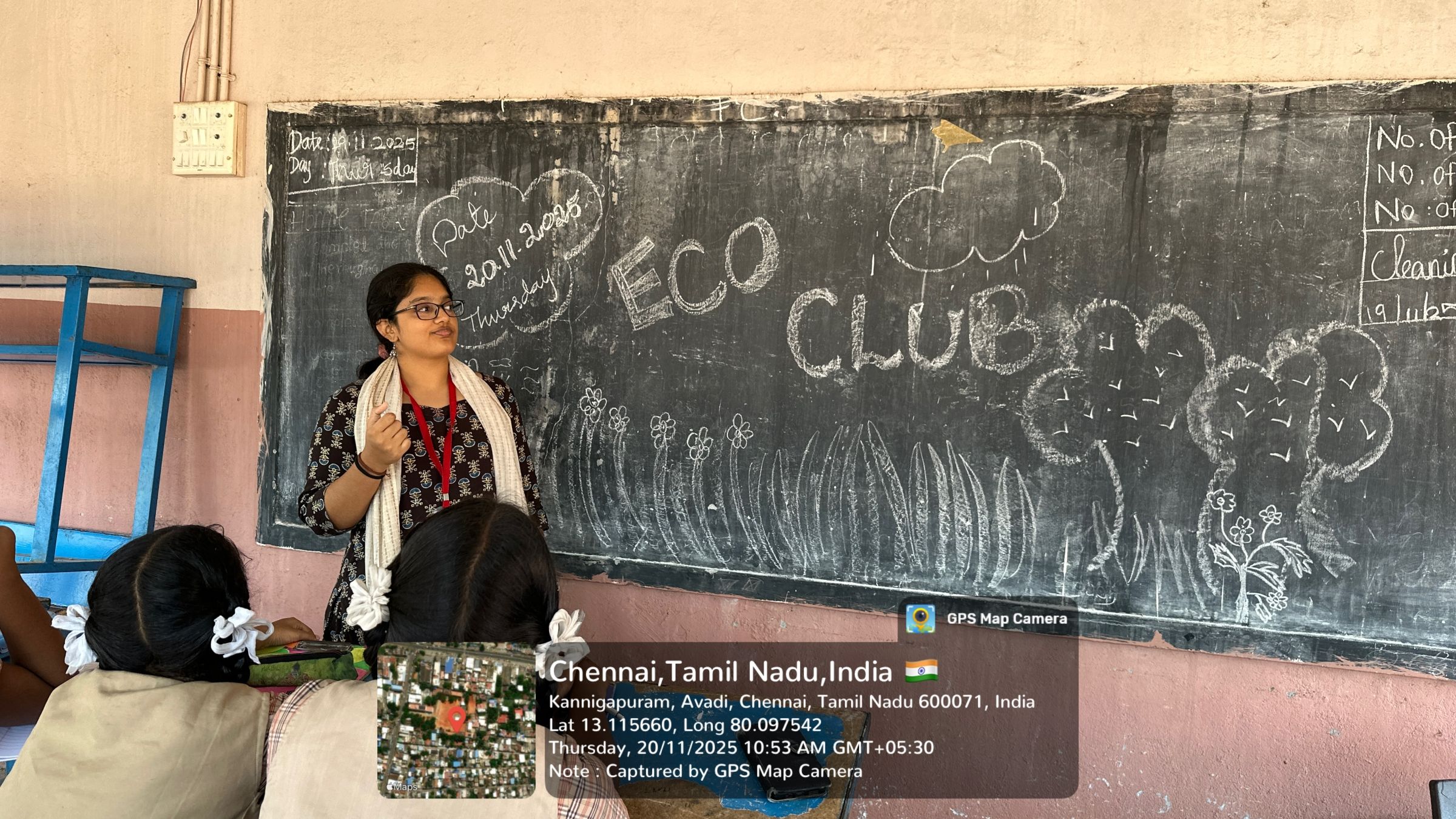 Anooja in front of a classroom chalk board
