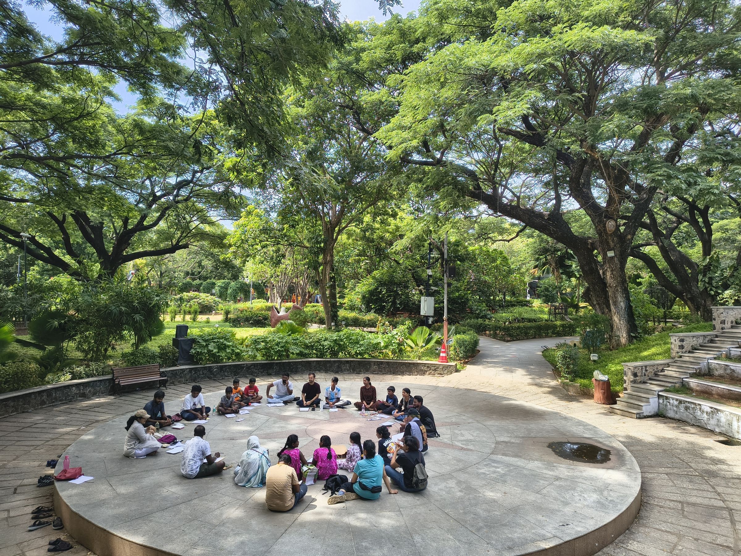 people sitting on the ground in a circle outside