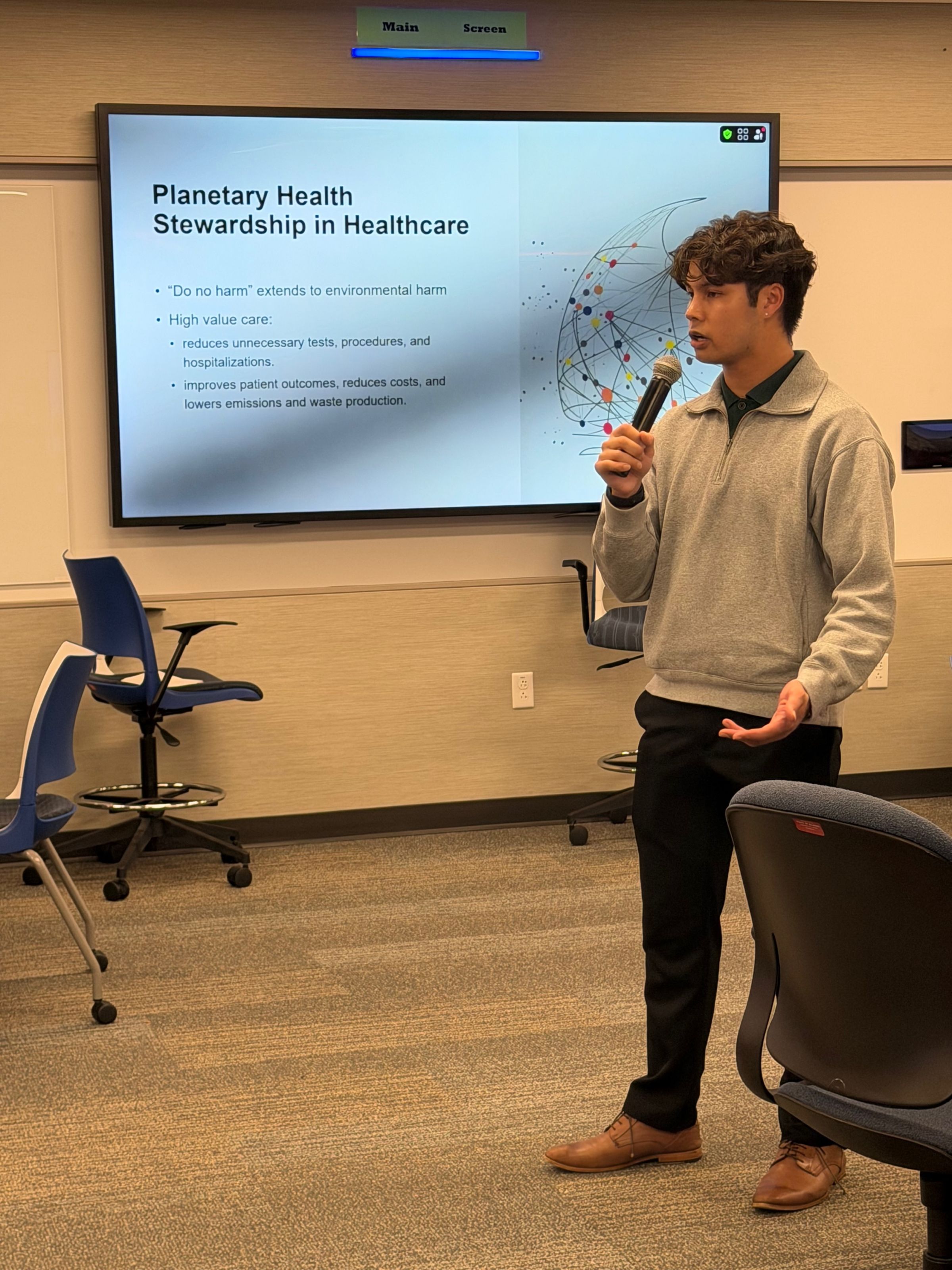 Austin speaking in front of a screen
