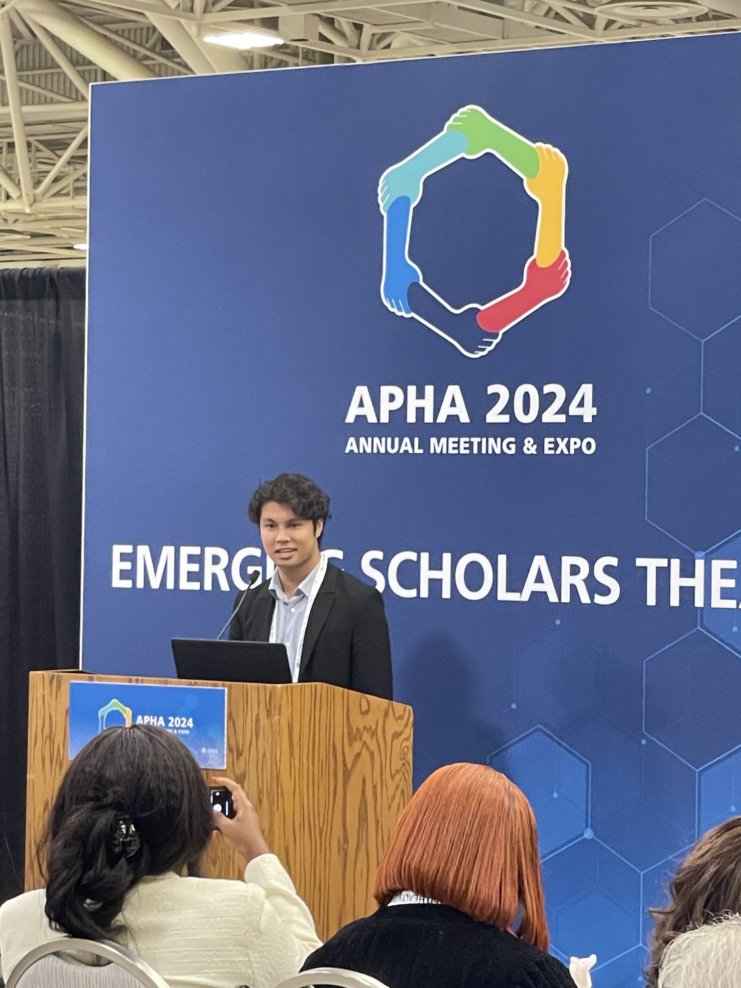 Austin speaking at a podium