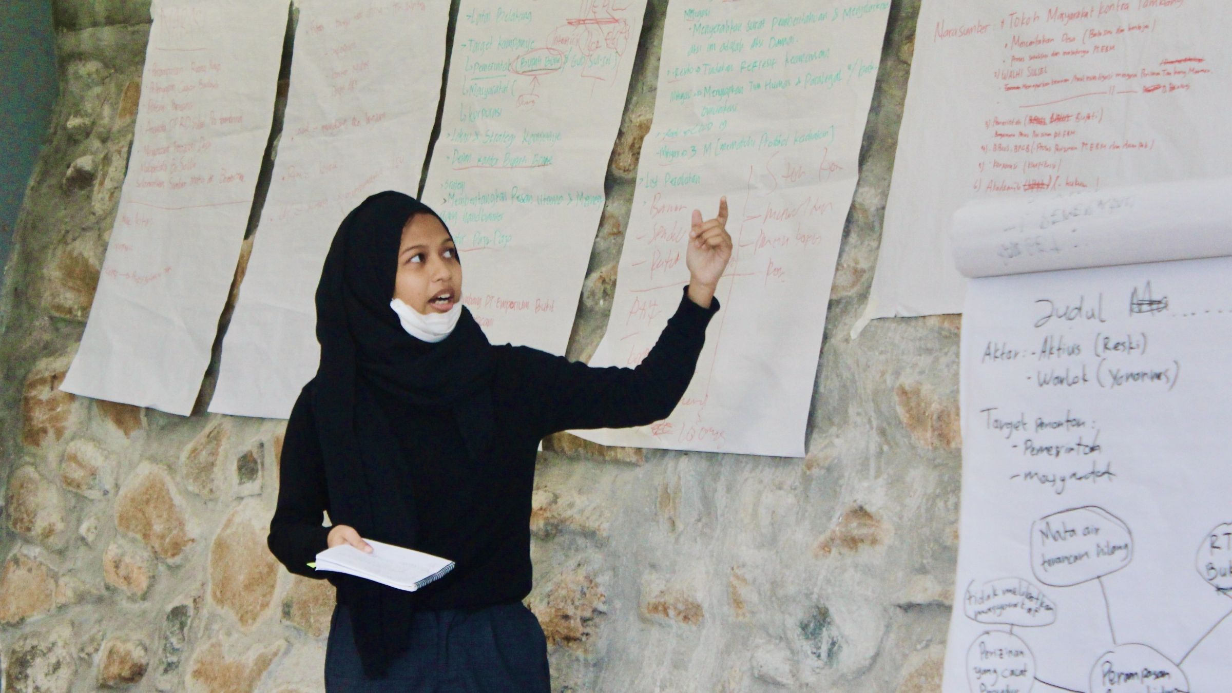 Lulu presents in front of handwritten flipcharts