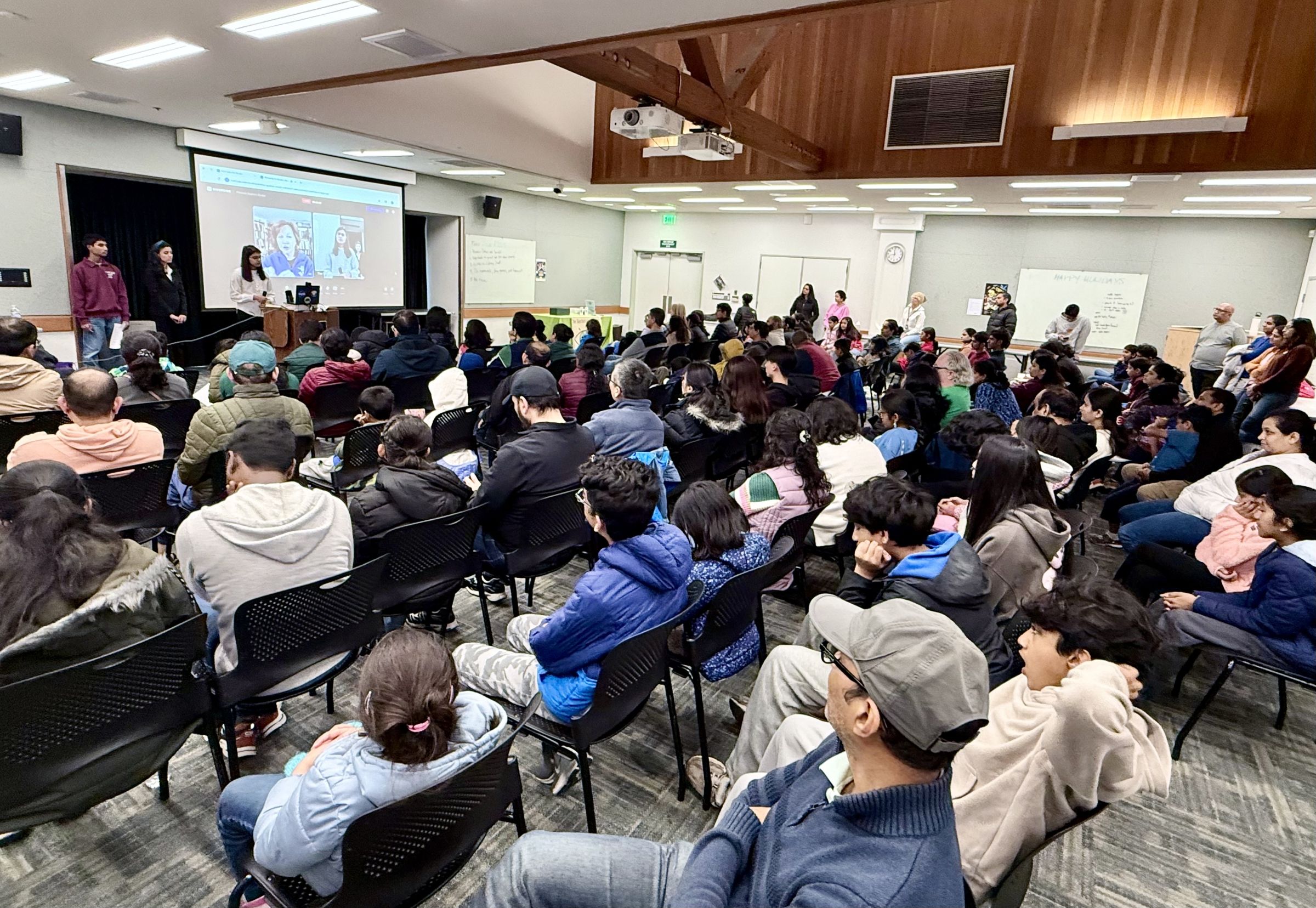 Pareena presenting in front of a large class of students