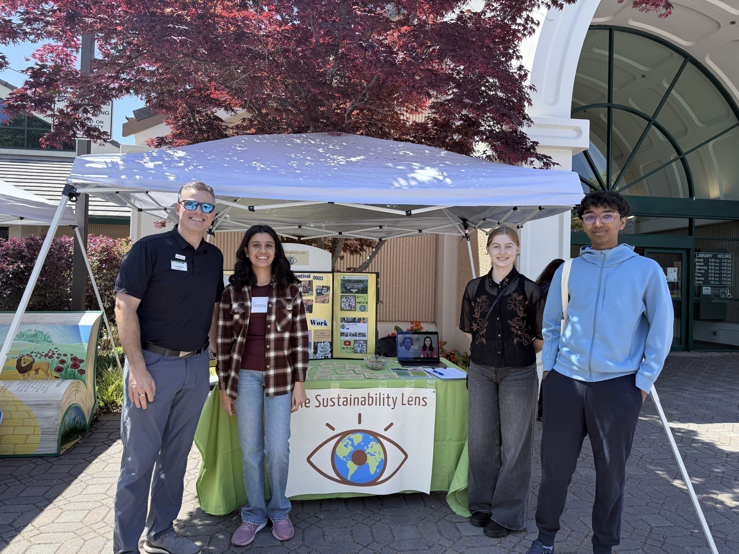 A group of four students near an outdoor vendor tent