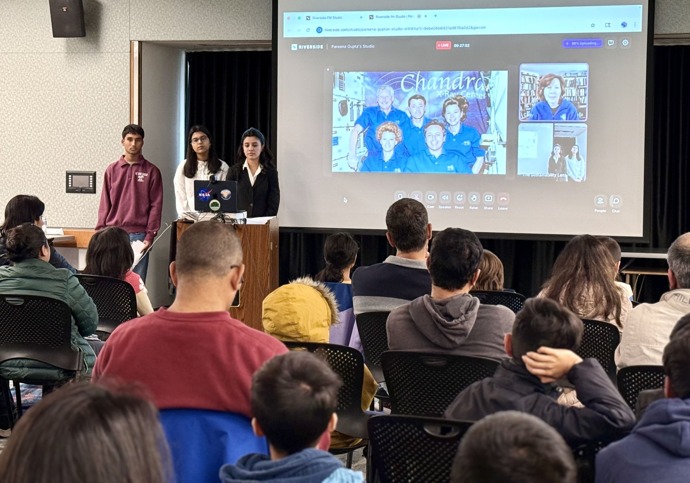 Pareena and other students present in front of a large audience