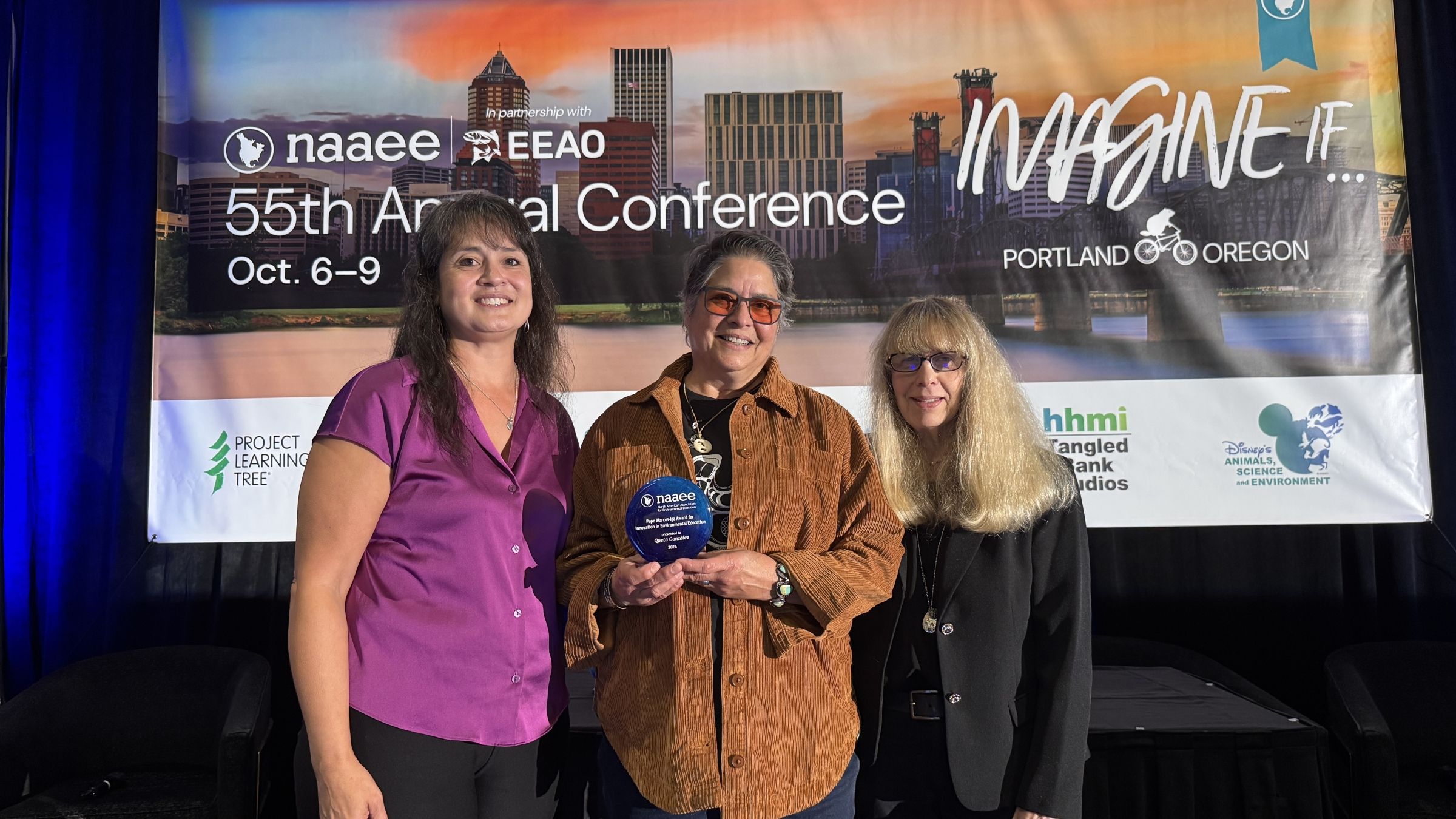 Queta accepts her award at NAAEE 2026.