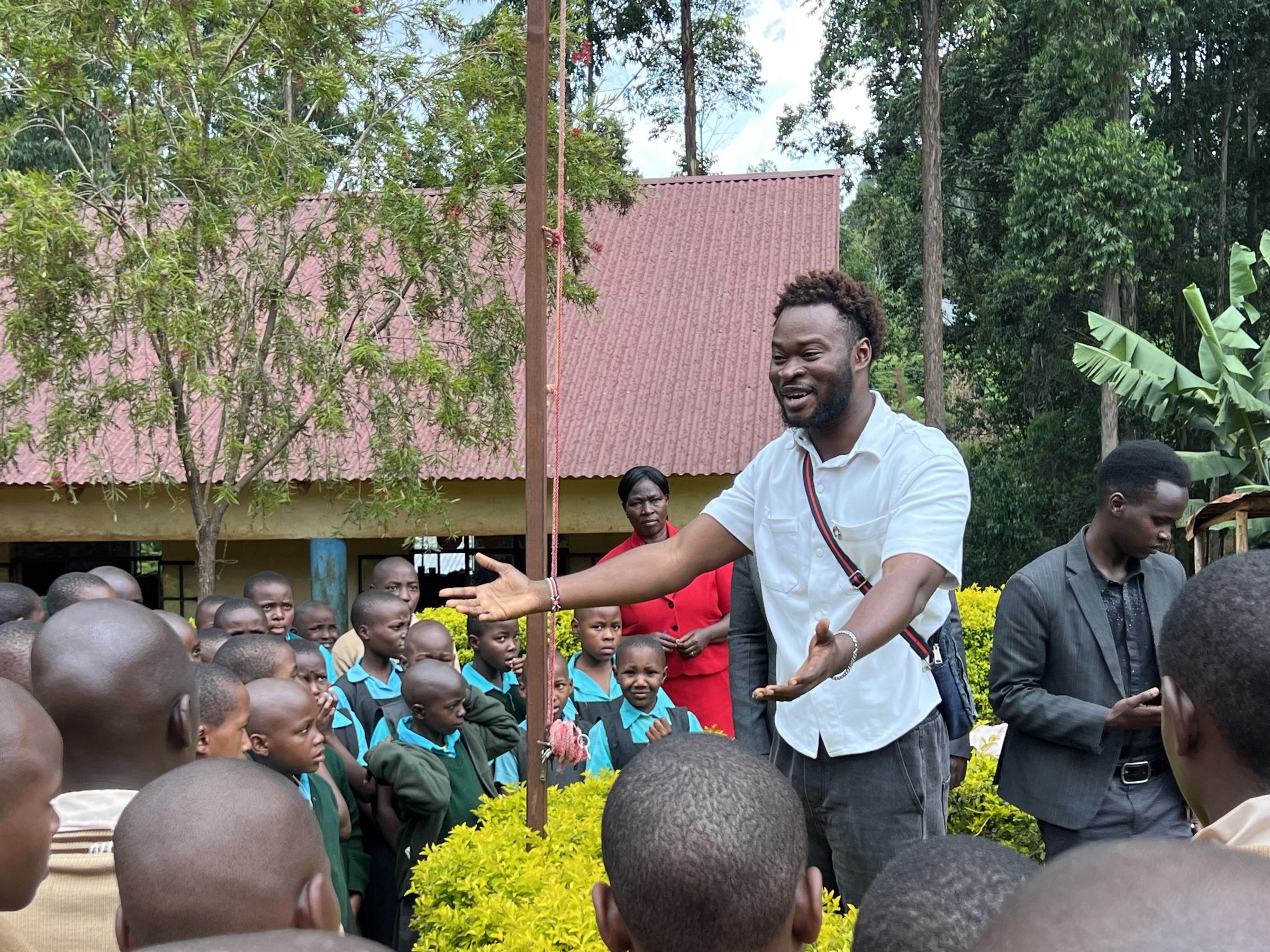 Solomon holds his arms out as he presents to students outdoors
