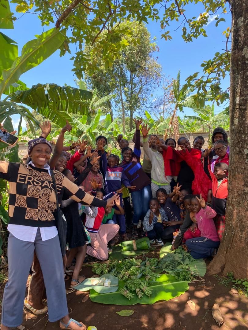 a group of young people posing by their garden