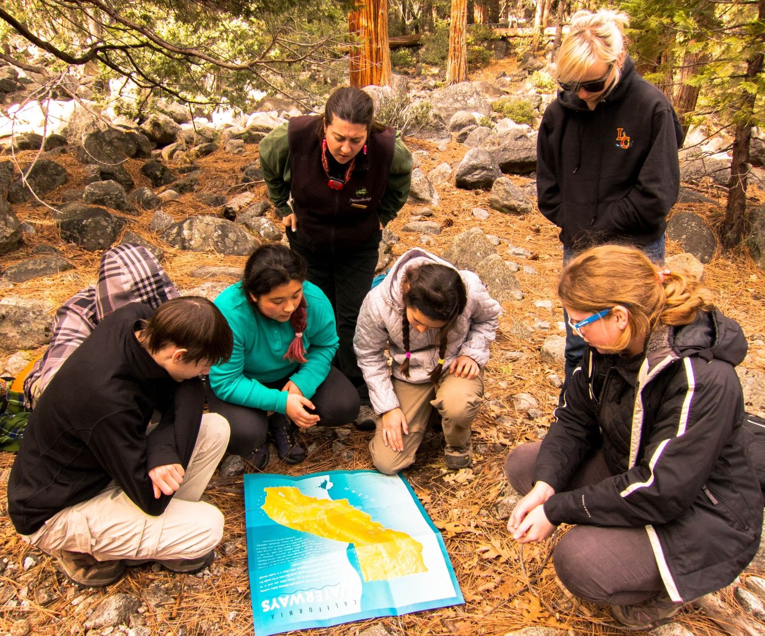 Group looking at a watershed map in a forest